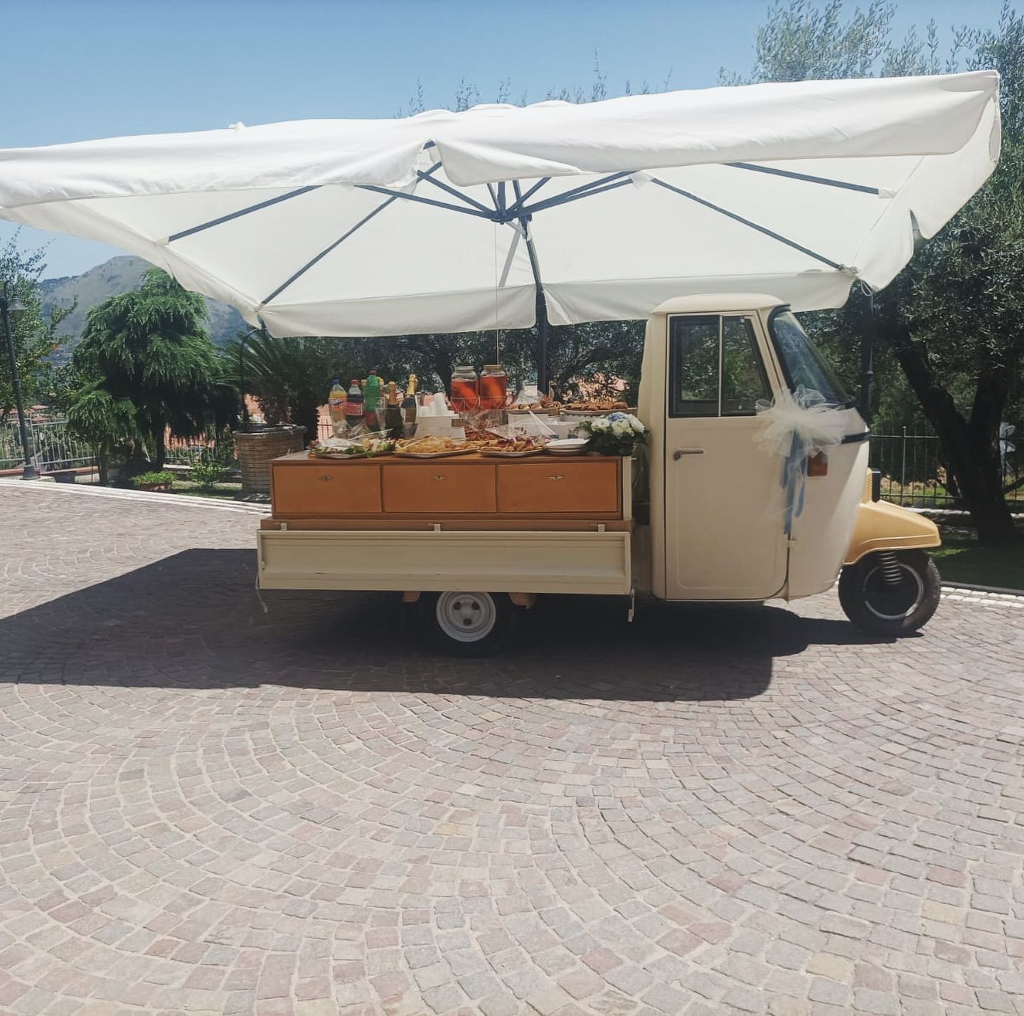 Un piccolo veicolo con un grande ombrello bianco sopra