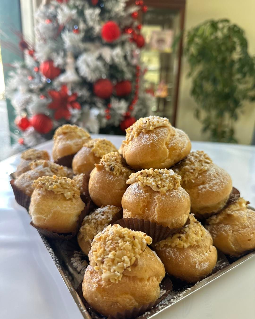 Sullo sfondo c'è un albero di Natale e sul tavolo c'è un vassoio di cupcake.