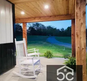 Two white rocking chairs on a porch overlooking a grassy path.