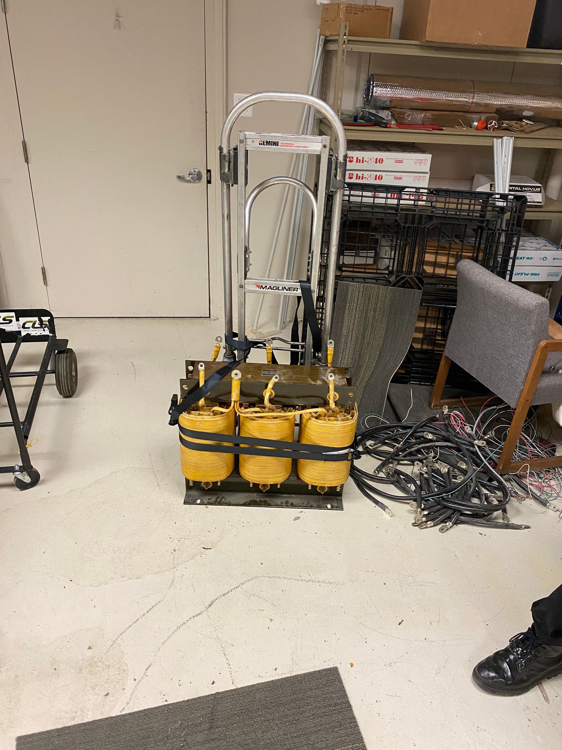A transformer is sitting on the floor in a room next to a chair.