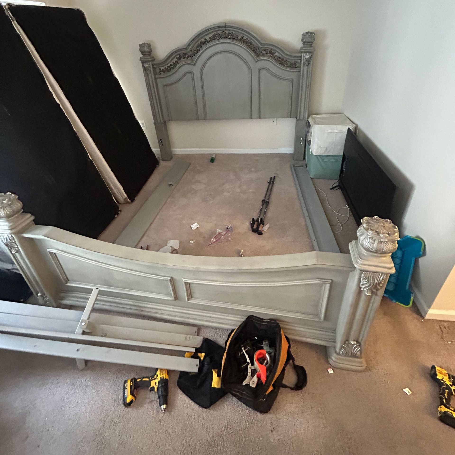 A bedroom with a bed and a bag of tools on the floor.