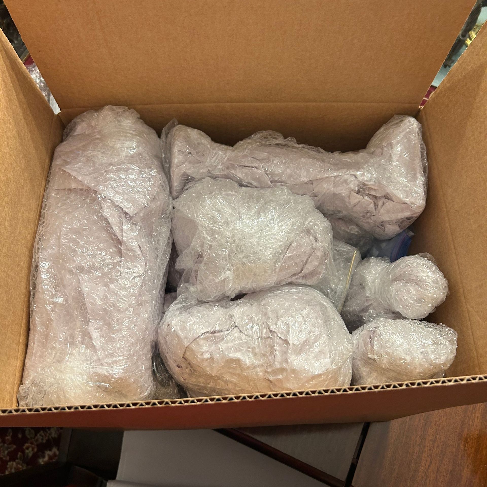 A cardboard box filled with bubble wrapped items