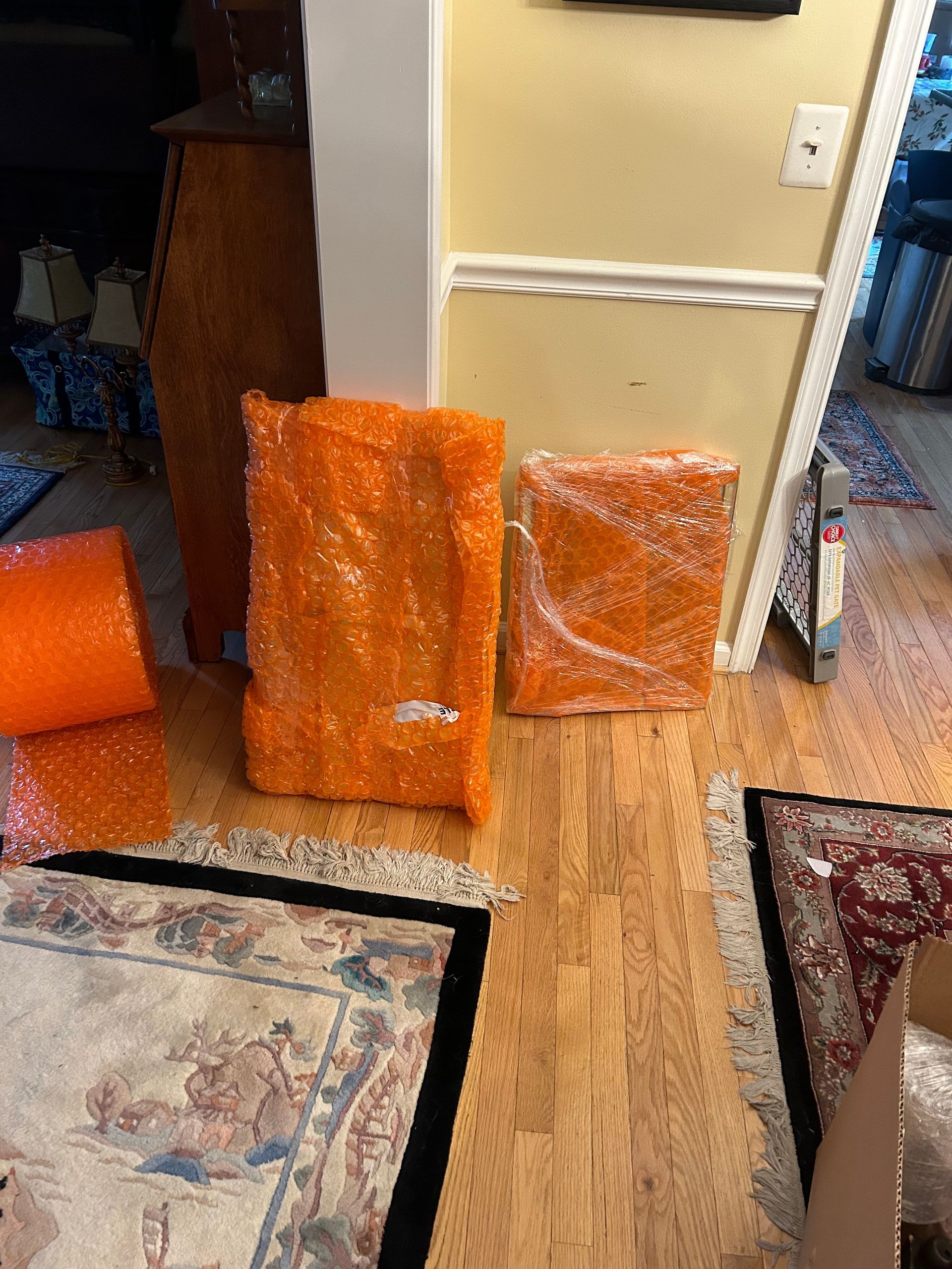 A living room with a rug and bubble wrap on the floor.