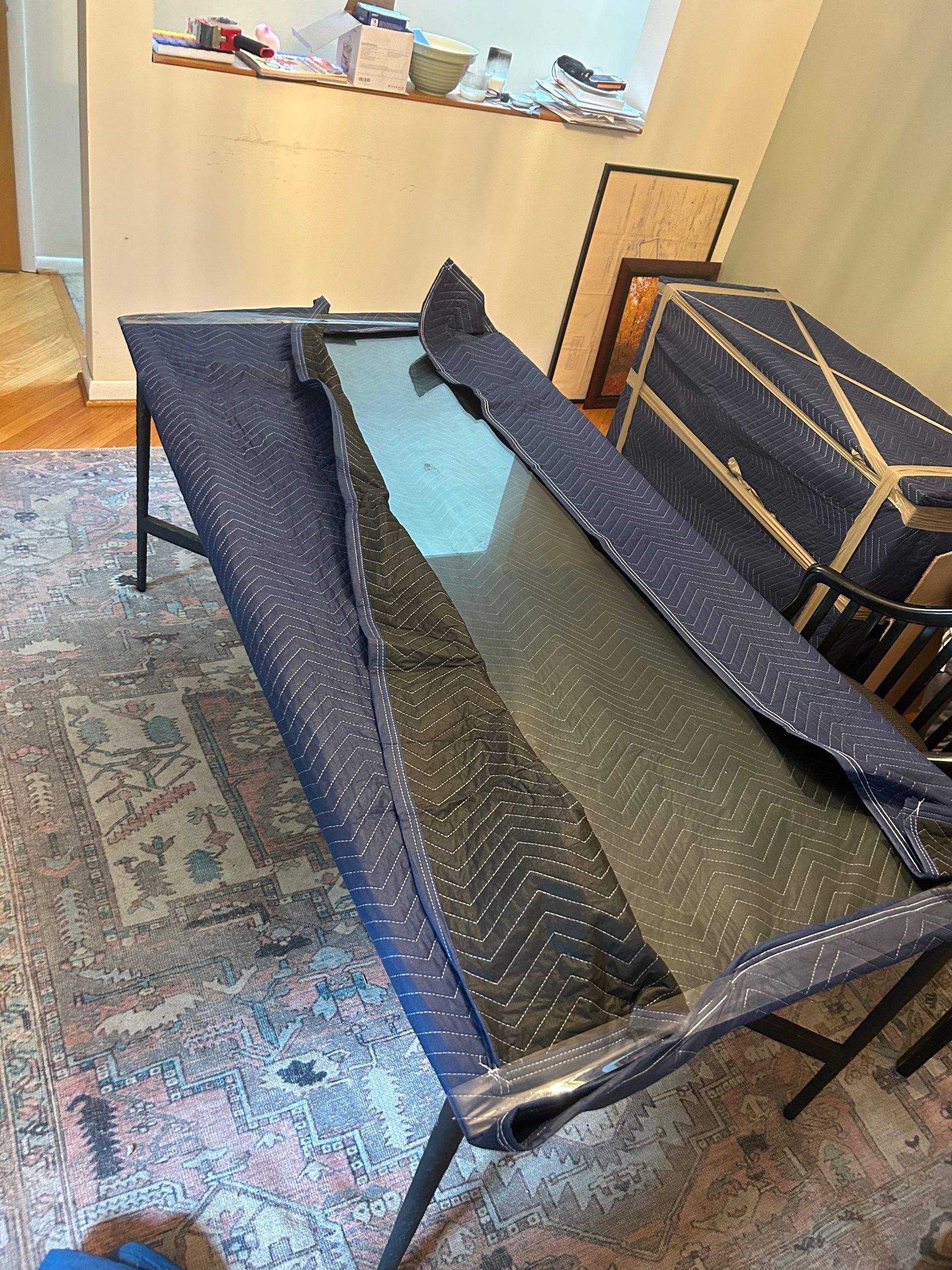 A glass table is sitting on top of a rug in a living room.