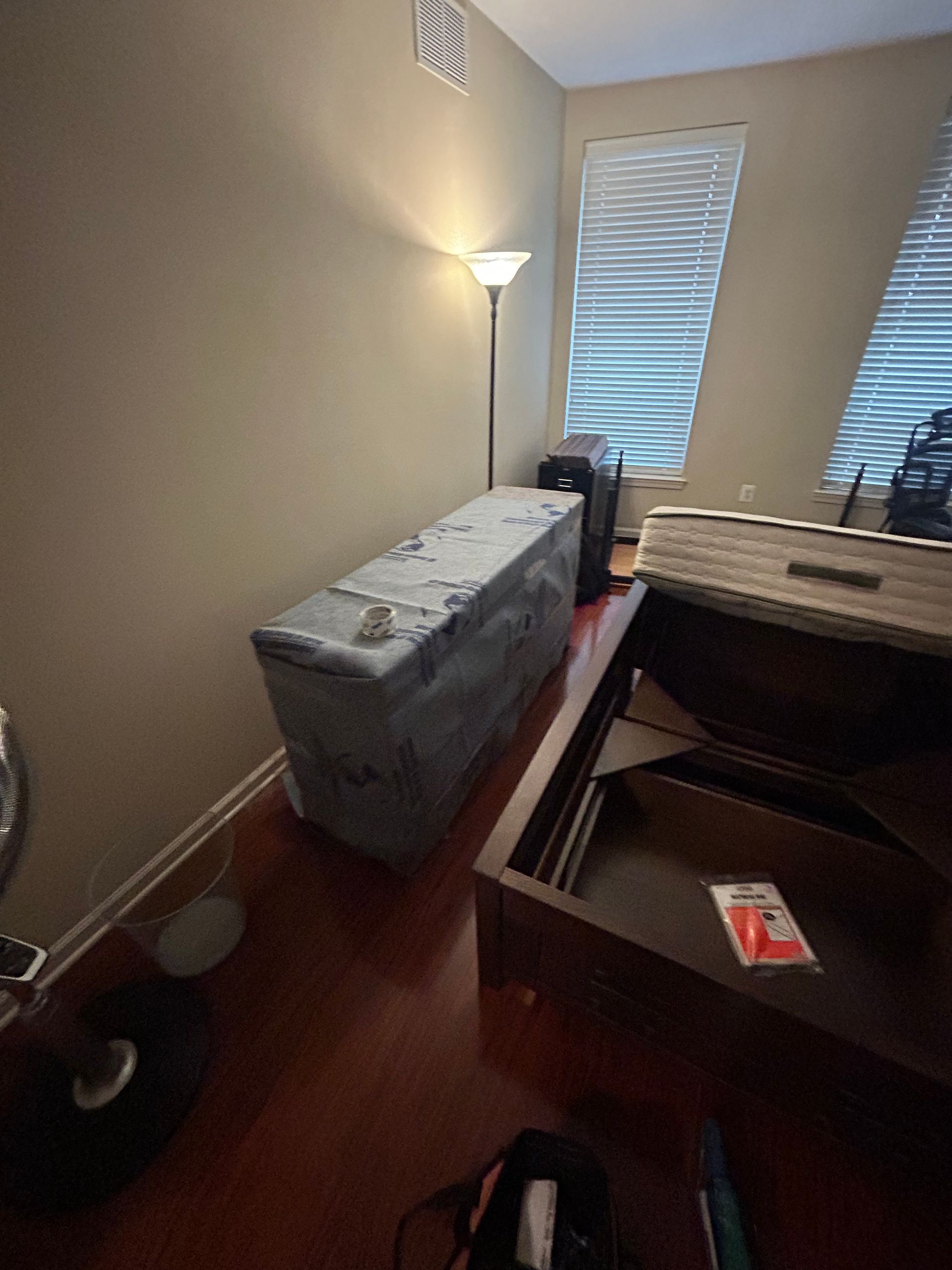 A room with a bed and a lamp in it.