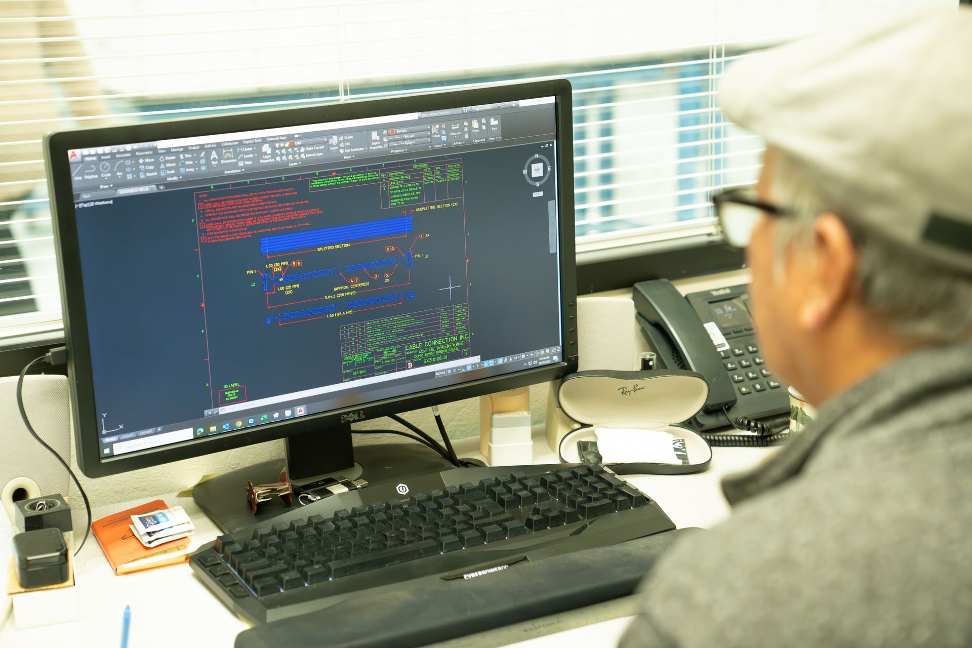 A man is sitting at a desk looking at a computer screen.