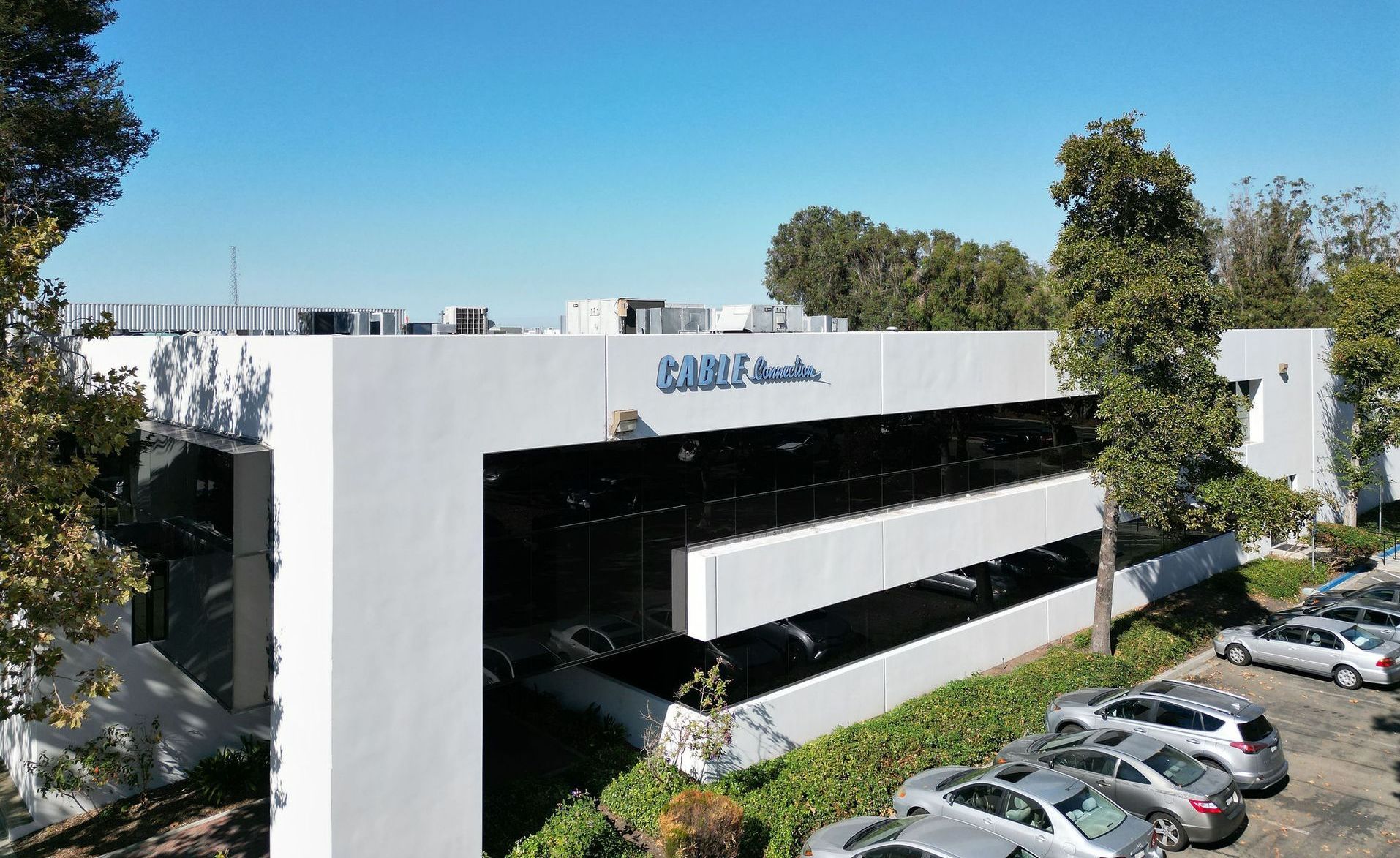A large white building with a lot of cars parked in front of it