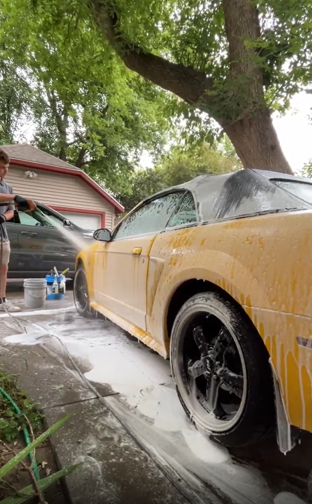 Professional foam wash exterior detailing of a dark SUV