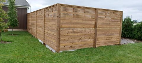 Wooden privacy fence in a grassy yard.