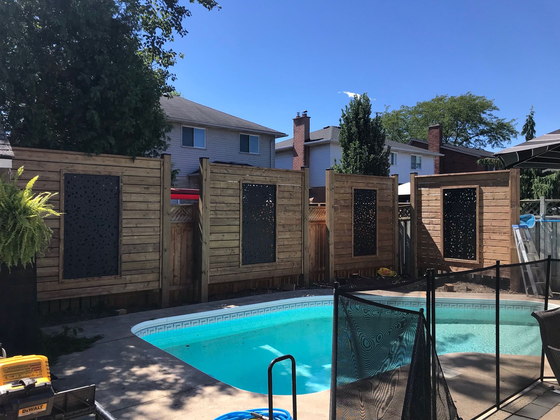 Pool with wooden privacy screens; sunny outdoor setting.