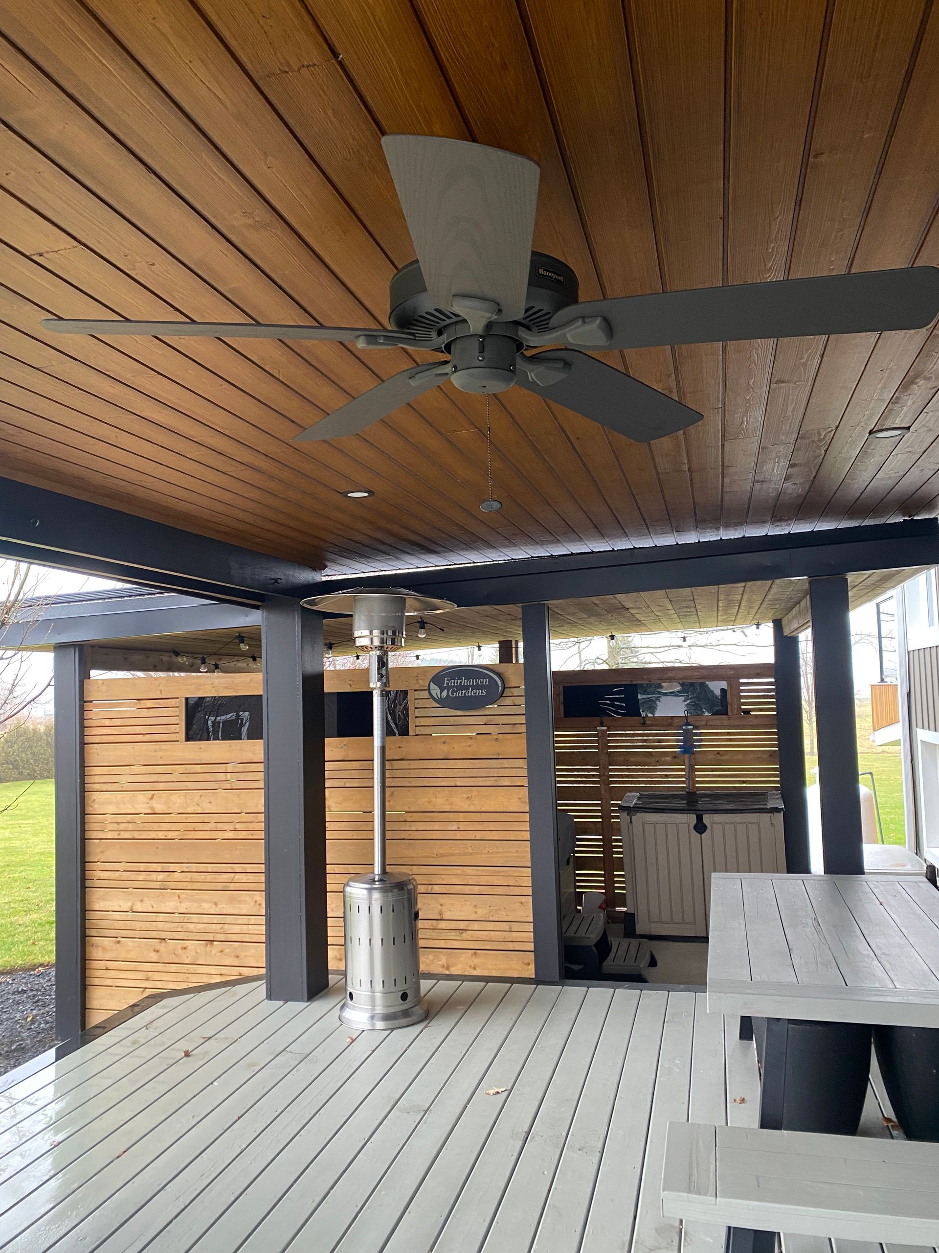 Covered patio with wood ceiling, ceiling fan, gray deck flooring, and outdoor seating area