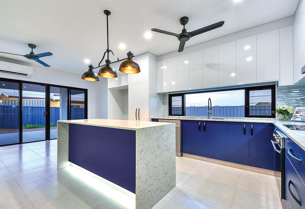 Modern kitchen with blue and white cabinets, island, and ceiling fans.