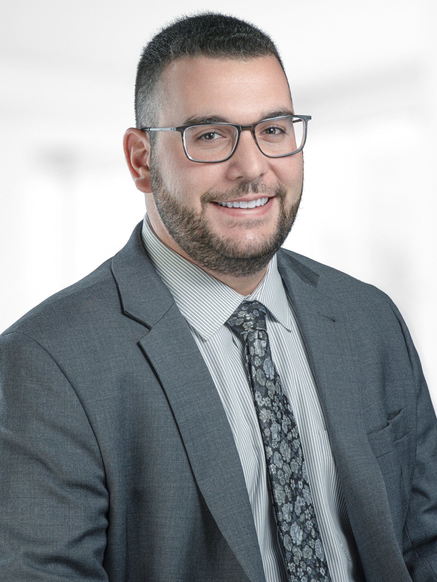 A man in a suit and tie is smiling for the camera.