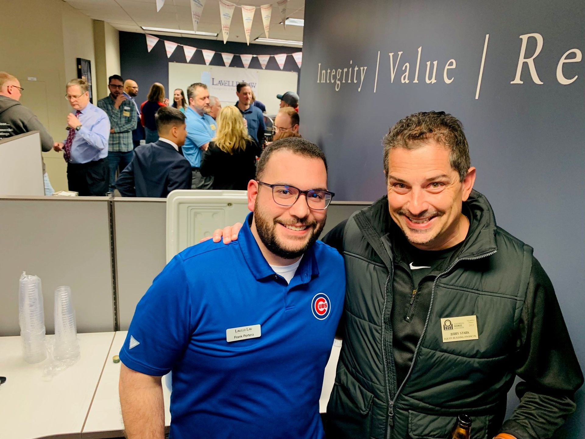 Two men are posing for a picture in front of a sign that says inspire value