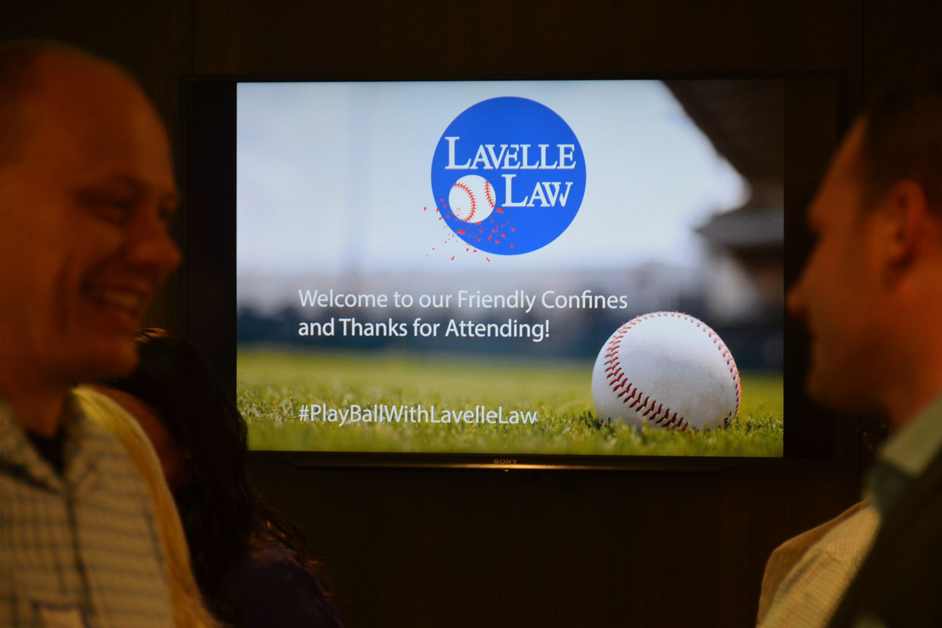 Two men are standing in front of a lavelle law sign