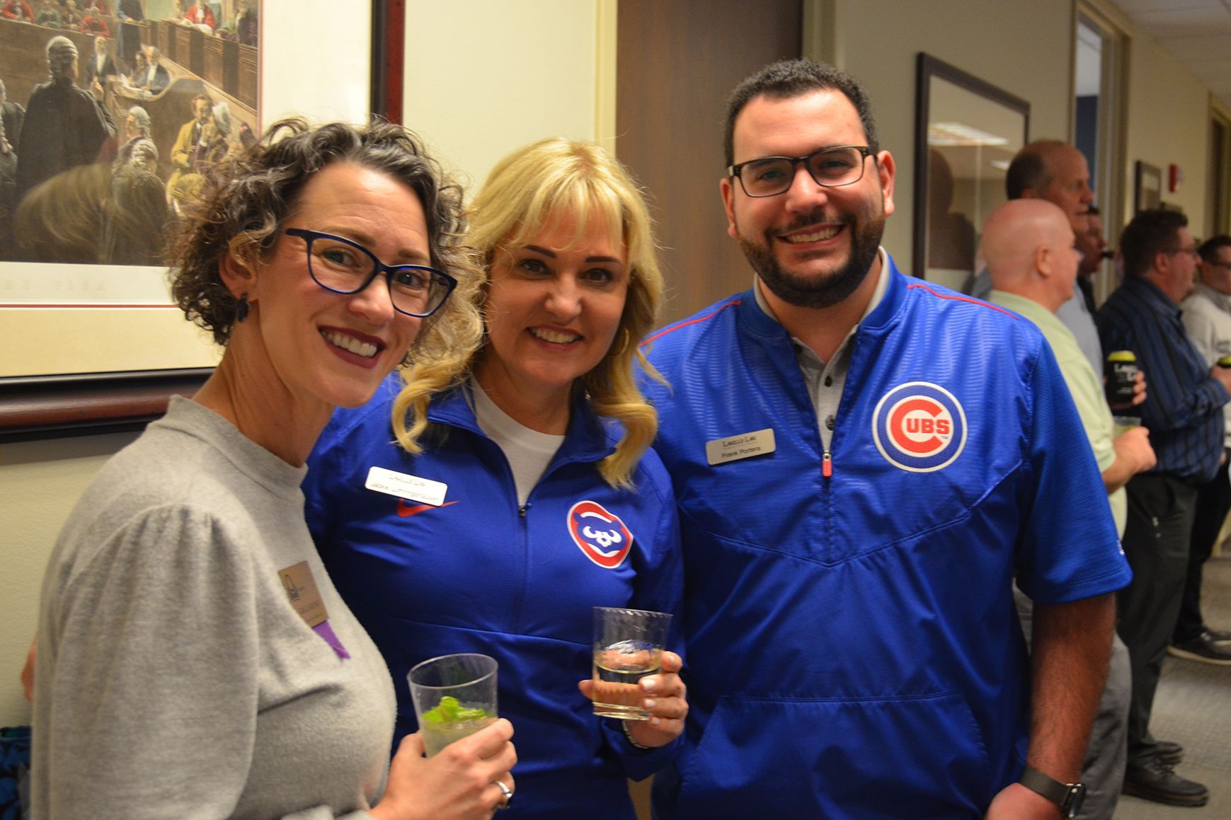 A group of people are posing for a picture and one of them is wearing a cubs shirt.