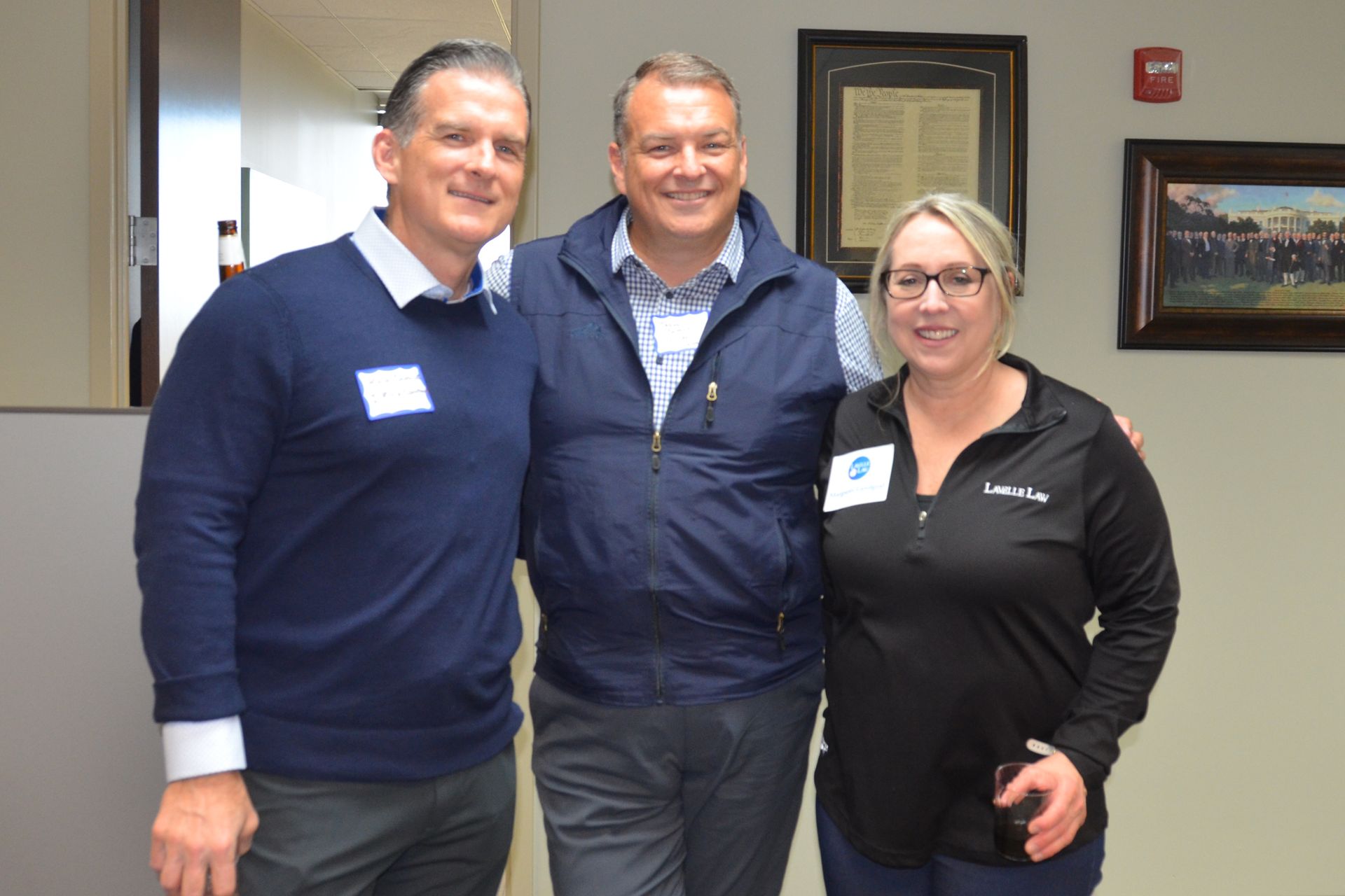 Three people are posing for a picture in a room.