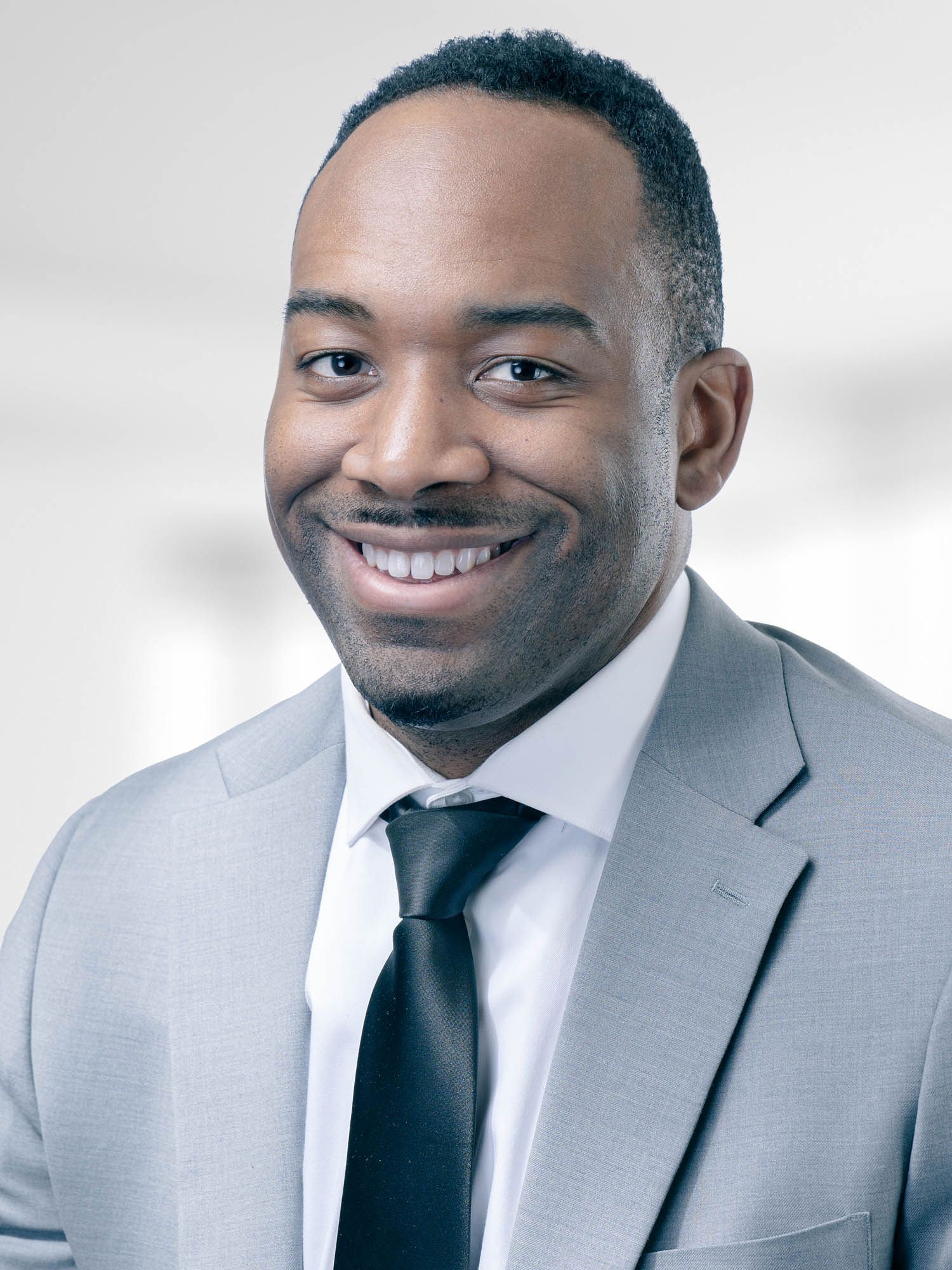 A man in a suit and tie is smiling for the camera.