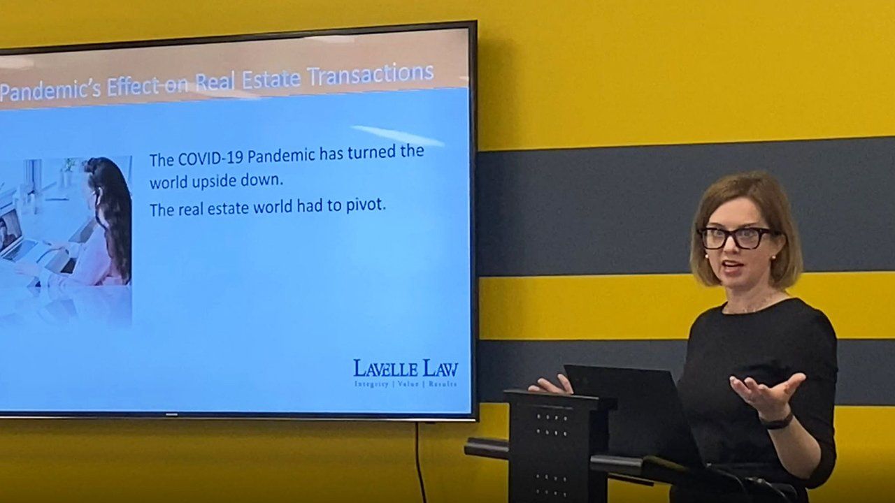 A woman is giving a presentation in front of a large screen.