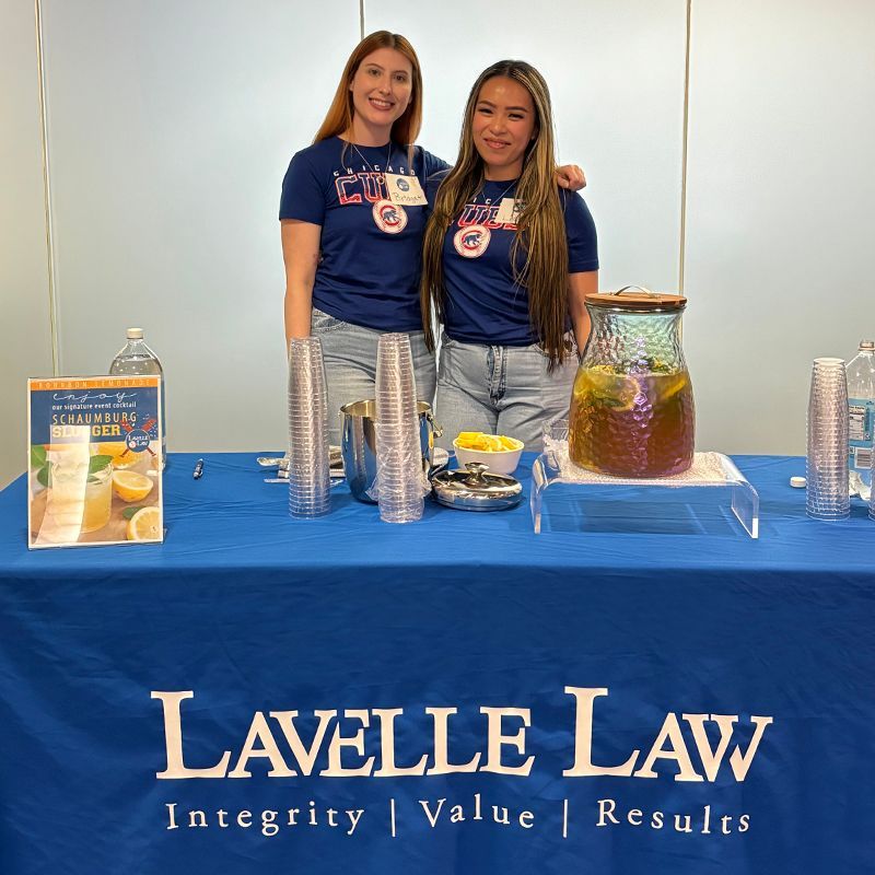 Two women standing behind a table that says lavelle law integrity value results