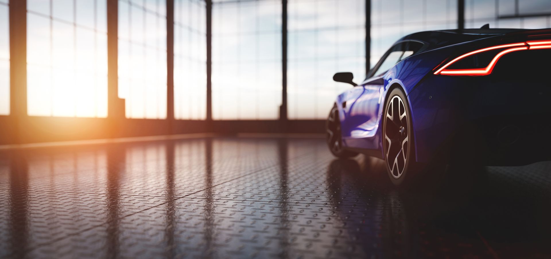 A blue sports car is parked in a garage with a lot of windows.