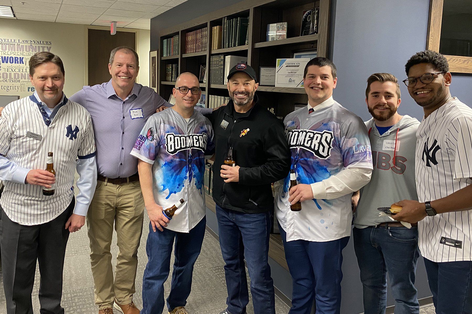 A group of men wearing baseball jerseys are posing for a picture.