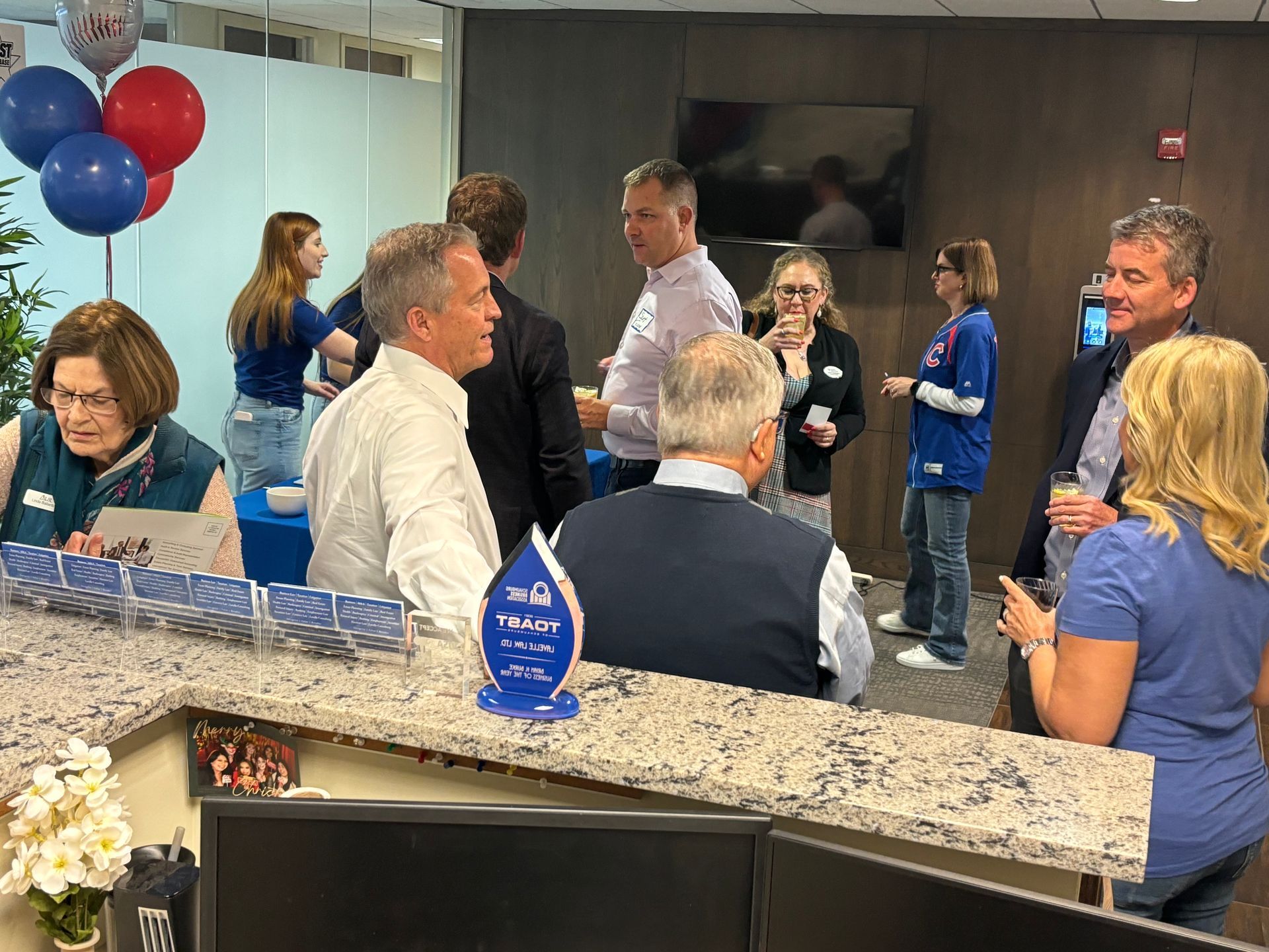A group of people are standing around a counter in a room.