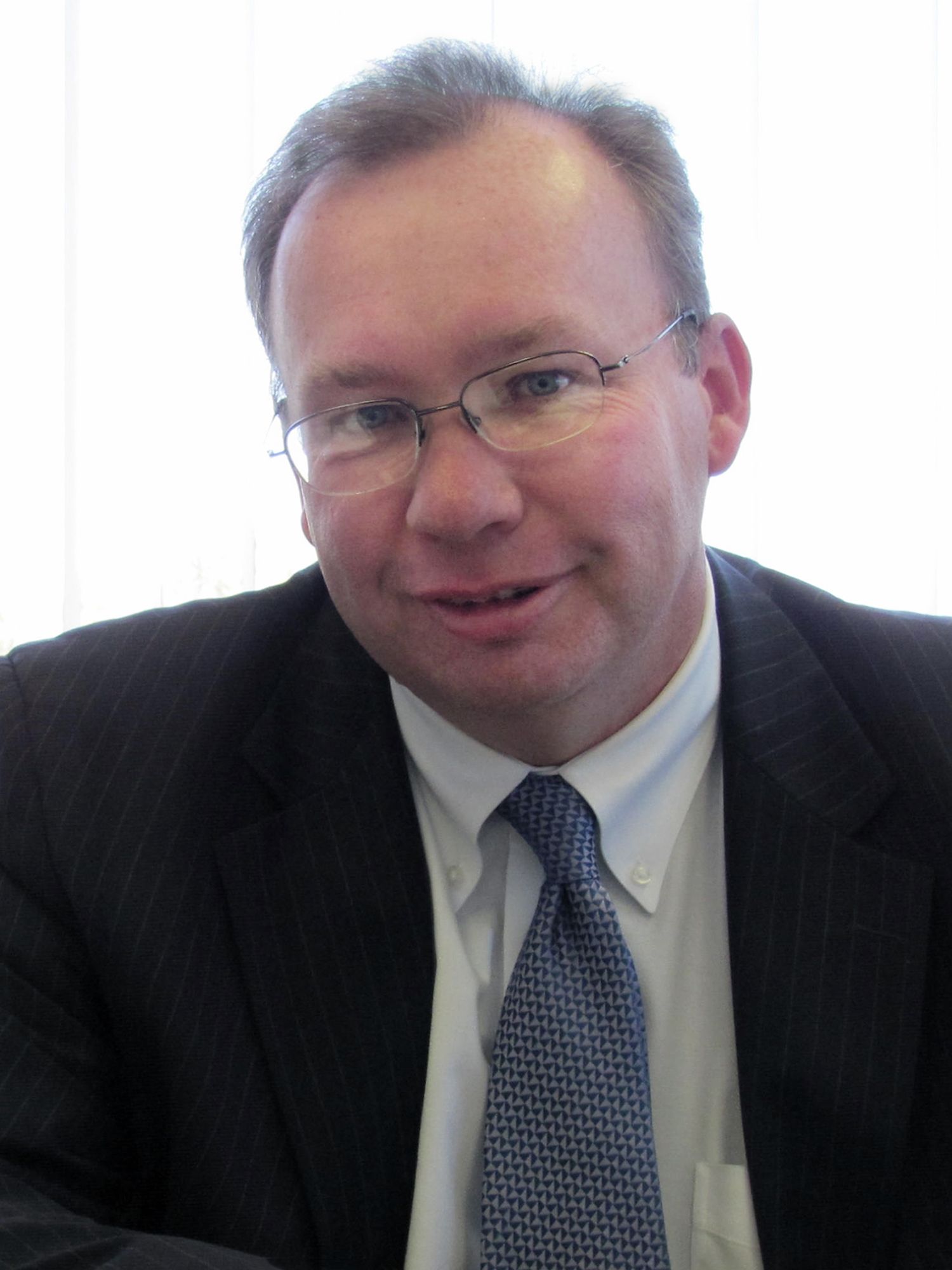 A man in a suit and tie is smiling for the camera