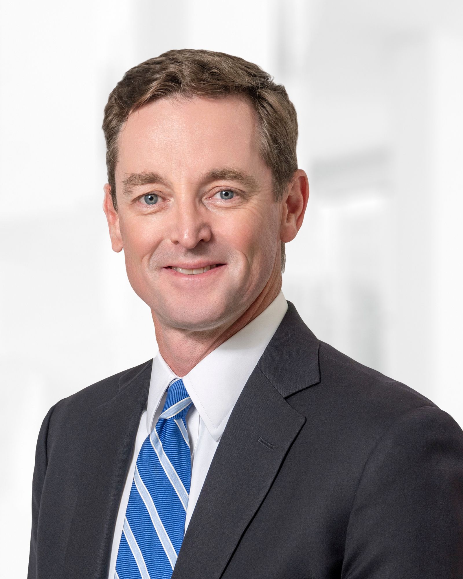 A man in a suit and tie is smiling for the camera.