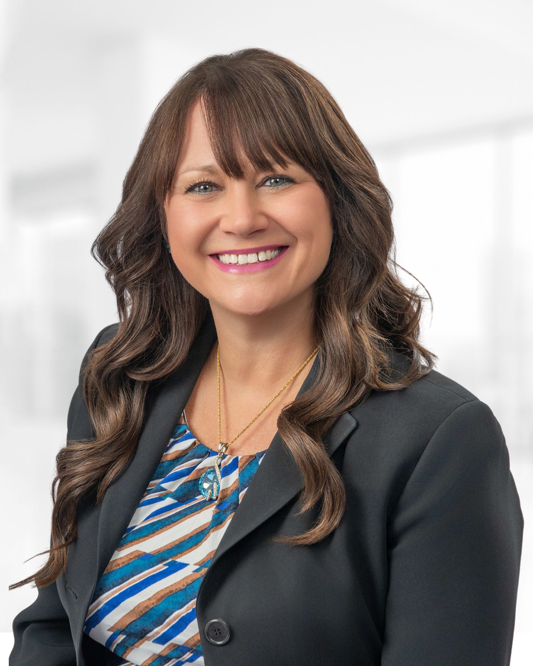 A woman in a black jacket is smiling for the camera