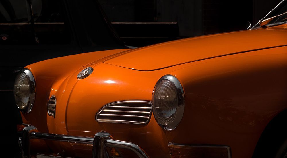 A close up of an orange car in a dark room.
