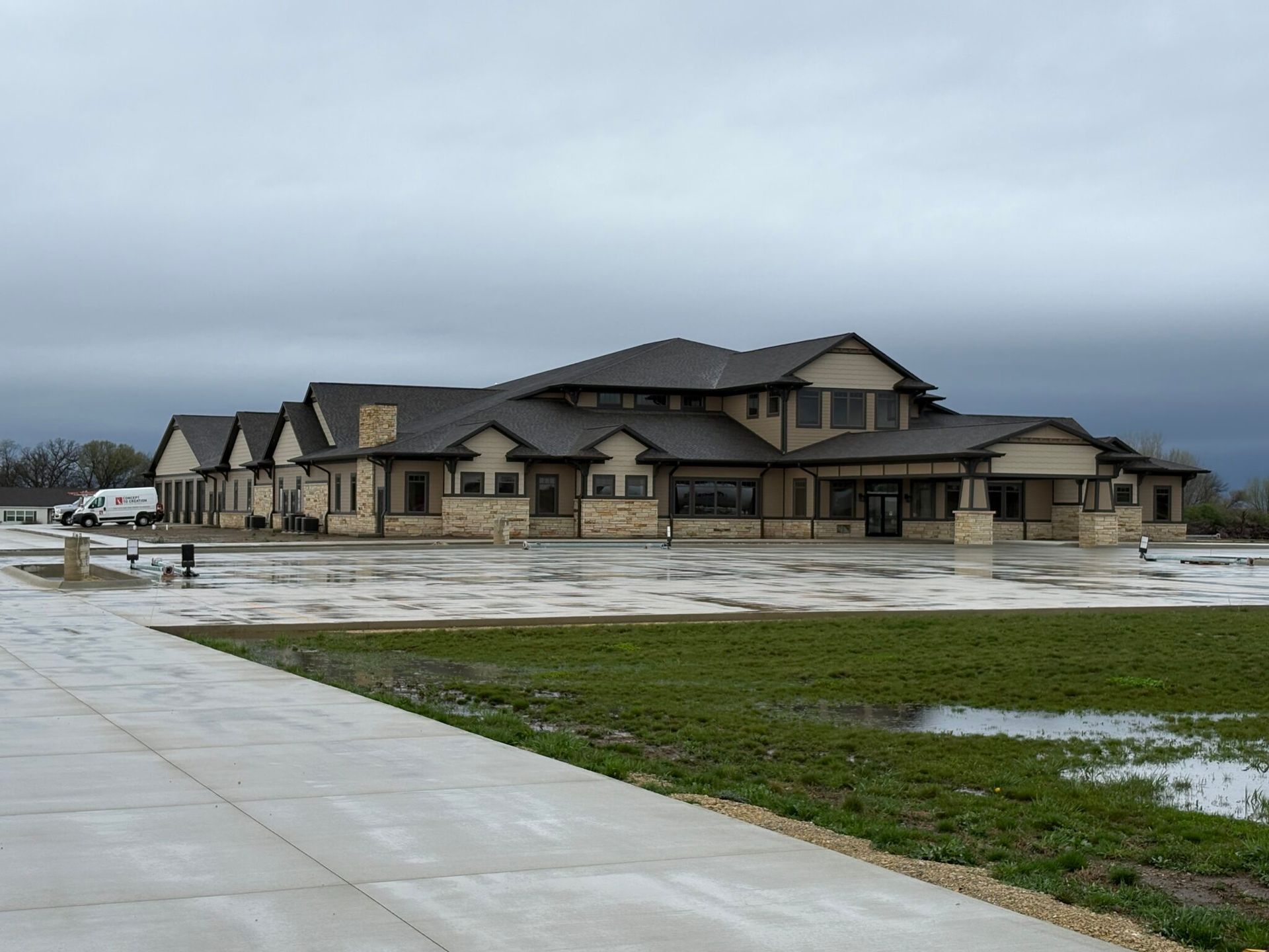 Large tan house with dark roof on a wet, grassy lot Large tan house with dark roof on a wet, grassy lot