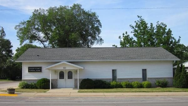 Single-story white building with a centered double door, black shutters Single-story white building with a centered double door, black shutters