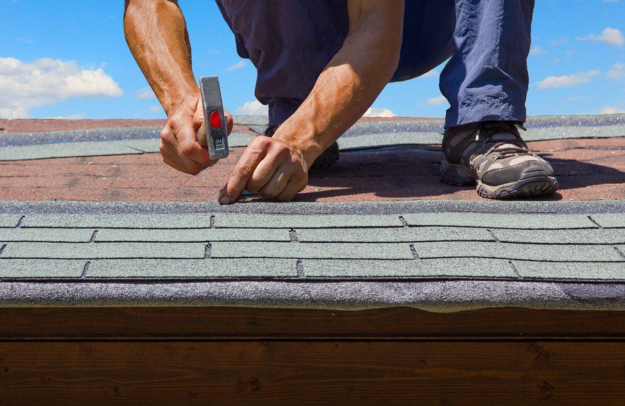 man using the hammer in the roof