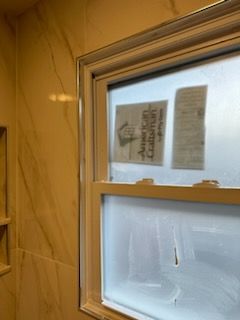 A bathroom window with a sign on it that says american caravan