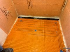 A person is measuring the floor of a bathroom with a level.