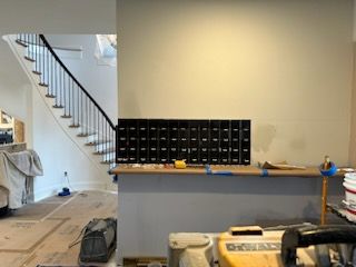 A staircase is visible in the background of a room under construction.