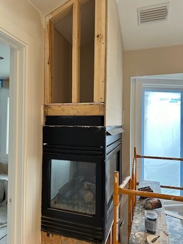 A fireplace is being built in a room in a house.