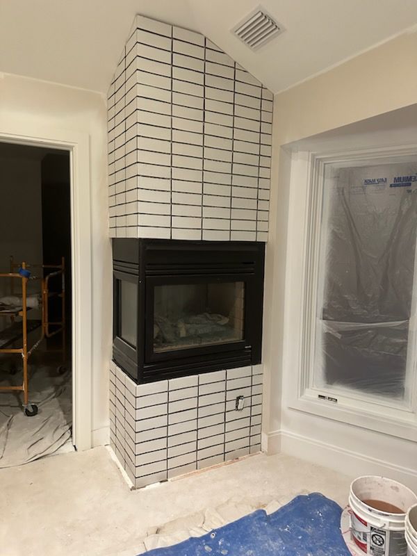 A living room with a fireplace and a window.