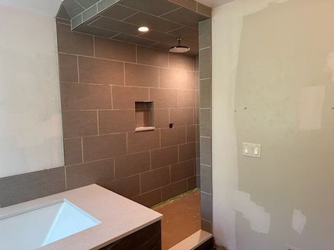A bathroom with a sink and a walk in shower.