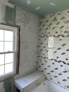 A bathroom with a bathtub and a window under construction.