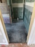 A bathroom under construction with a tiled floor and a sink.