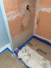A bathroom is being remodeled and a shower is being installed.
