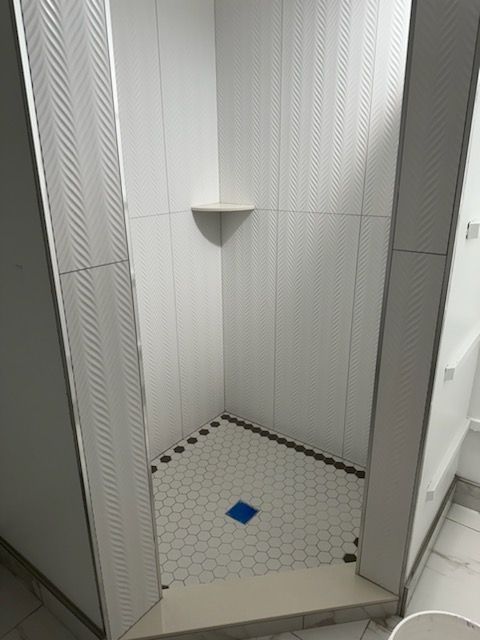 A bathroom with white tiles and a blue tile floor