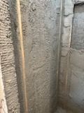 A room with a concrete wall and a window.