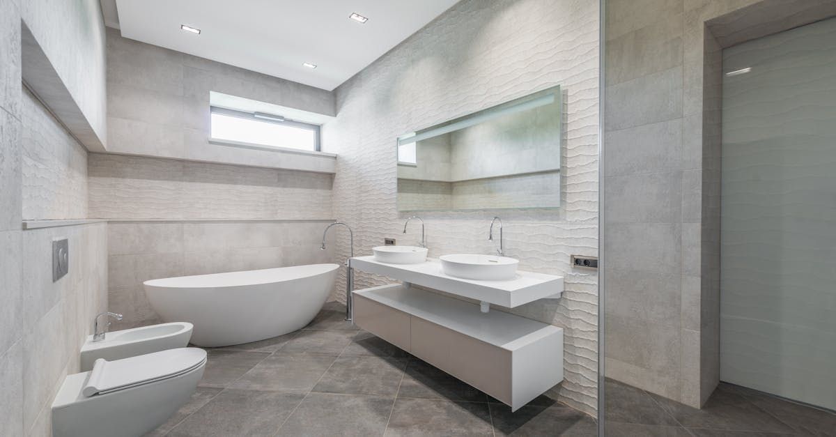 A bathroom with a bathtub , sinks , toilet and mirror.