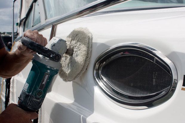 Buffering a white car’s round taillight with a power polisher
