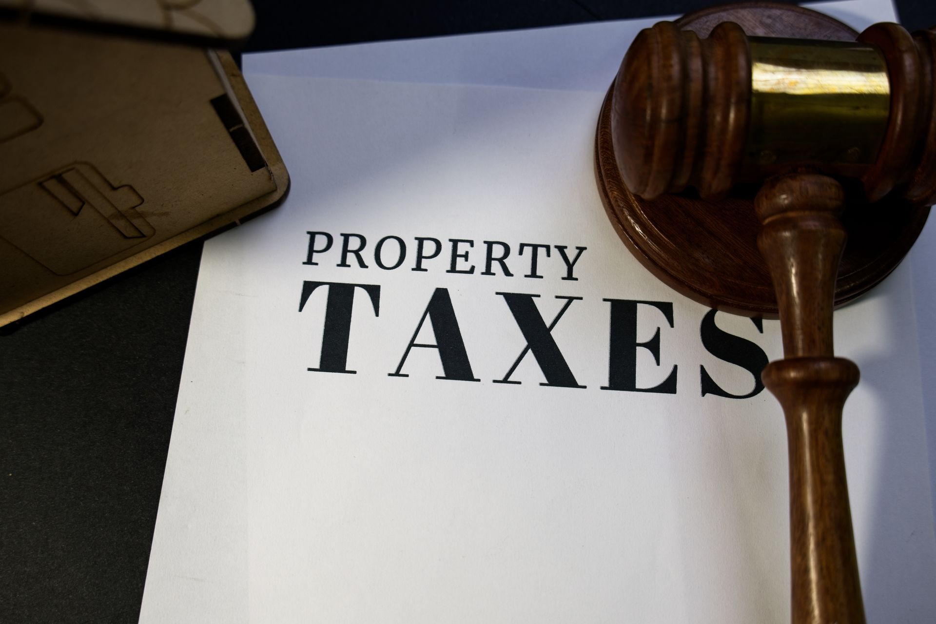Gavel resting on a document labeled “Property Taxes.” Gavel resting on a document labeled “Property Taxes.”