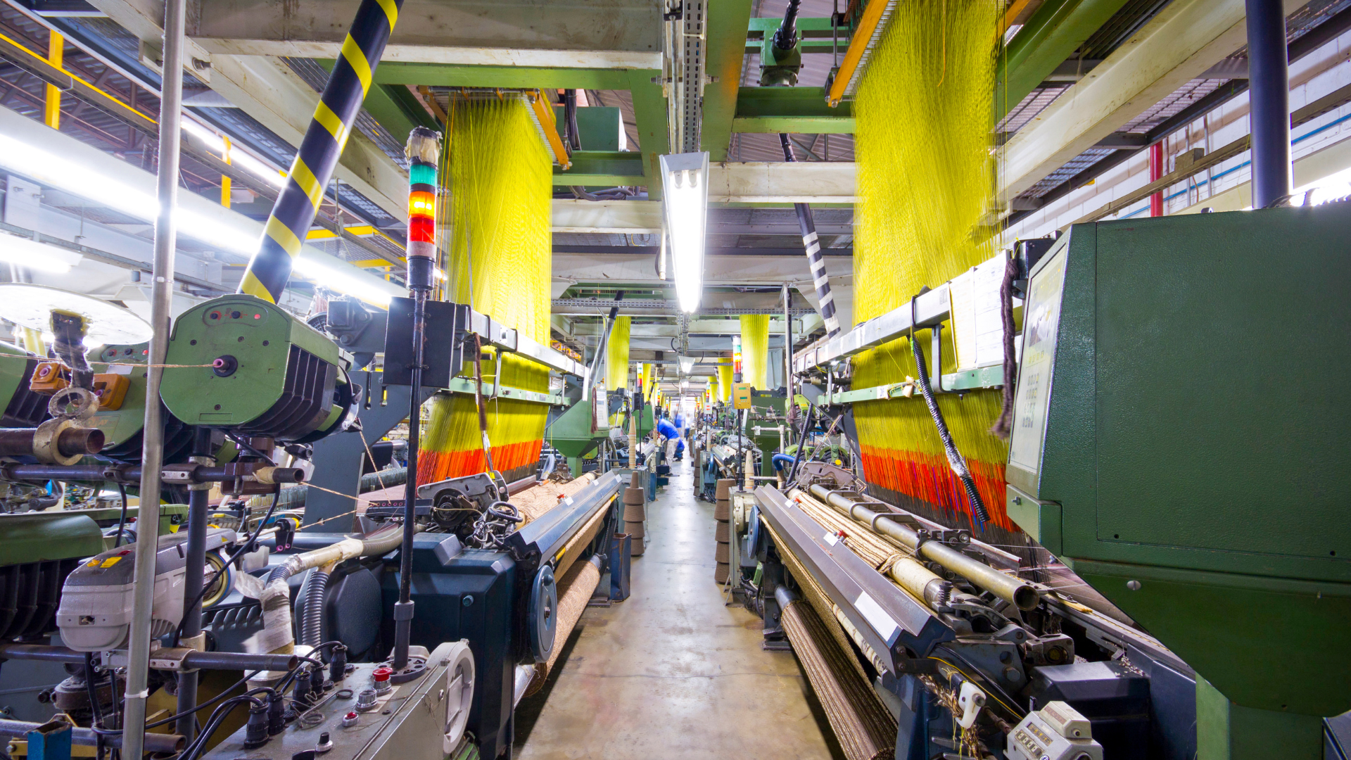 Textile factory with weaving machines and yellow fabric.