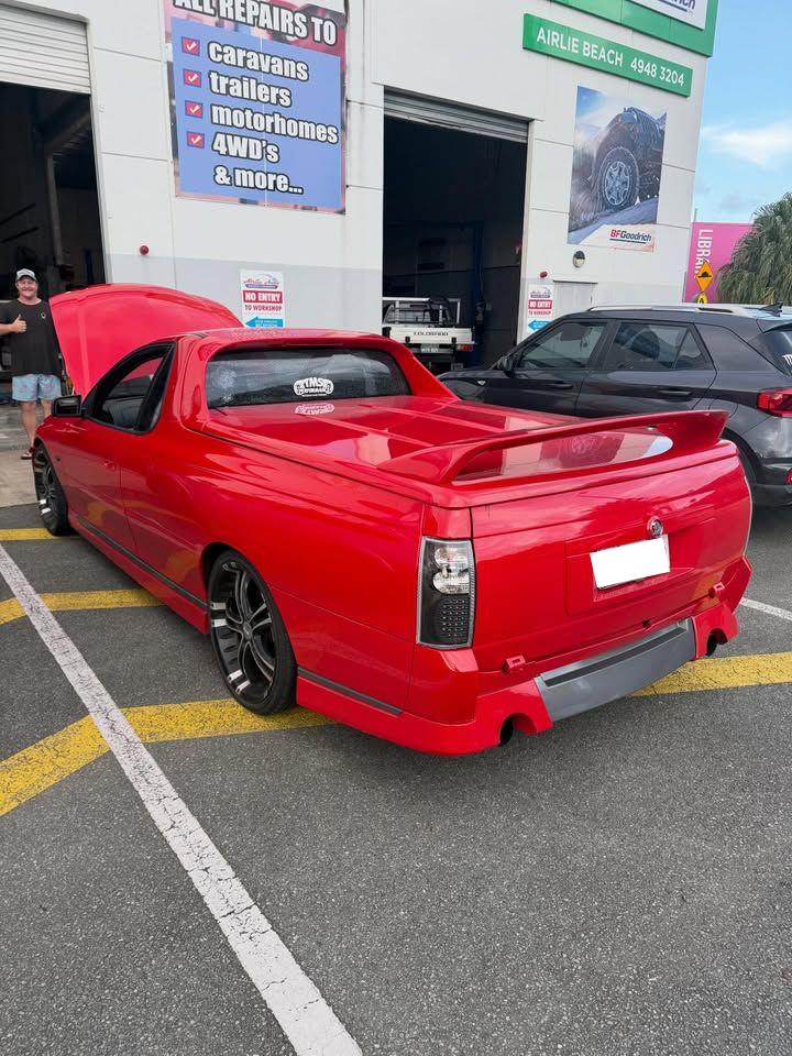 A Bright Red Holden Ute With a Raised Hood and a Rear Spoiler Parked — Elite Fleet Auto - Electrics & Mechanical in Townsville, QLD